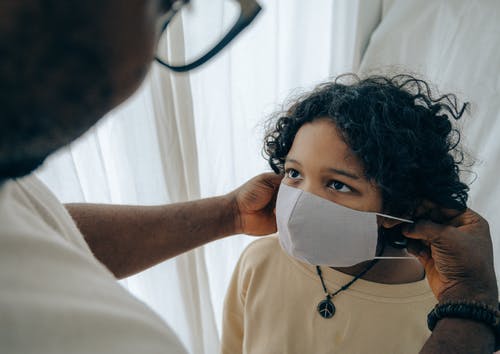 parent putting a mask on a child